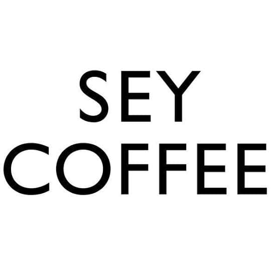SEY Coffee homepage with Drink Beautiful Coffee in condensed type over a photo of a cupping table from above